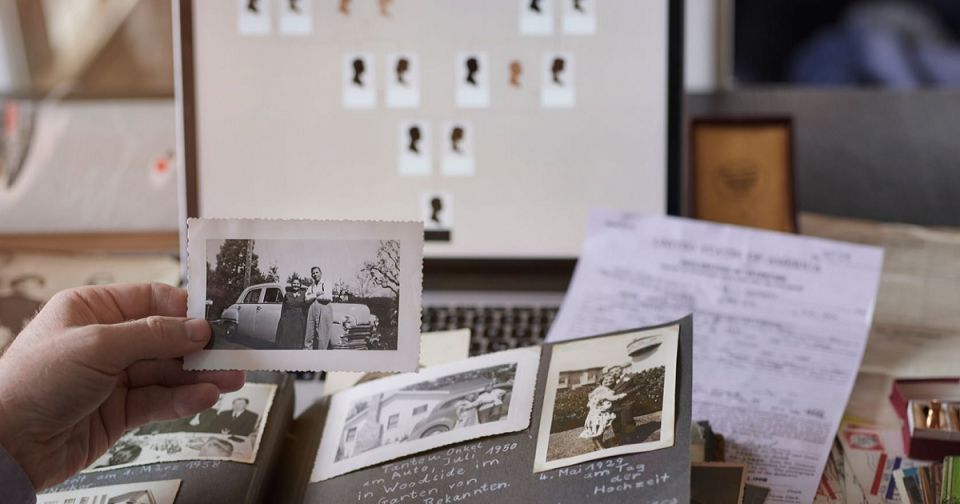 Someone holding an old photo above a photo book